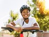 Lachender Schüler mit den Armen auf das Velo-Lenkrad gestützt