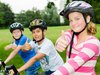 Drei Schüler:innen auf dem Velo mit Daumen hoch