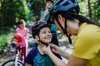 Una madre mette il casco a suo figlio