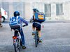 Un bambino con bicicletta e casco alza il pollice verso l’obiettivo